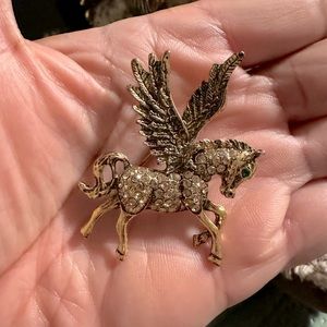Unicorn gold tone brooche with an emerald eye.